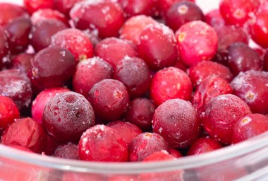 Donmuş yaban mersini, beyaz arka planda yakın plan. Donmuş kırmızı meyveler.