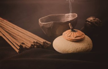 Karanlık bir arka planda sandal ağacı tütsüsü içmek. Estetik nedenler, aromaterapi, meditasyon ve tören için kullanılır..