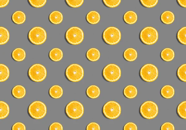 Fruit pattern from slices of orange on a gray background. Flat lay