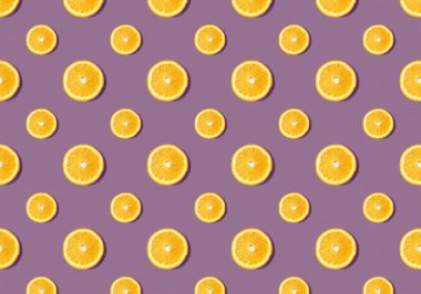 Mor arkaplandaki turuncu dilimlerden gelen meyve deseni. Düz yatıyordu