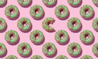 Pembe arka planda pürüzsüz yeşil çörek deseni var. Yaklaş..
