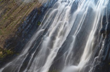 Kayalarda güzel bir şelale. Düşen suyun fotoğrafı. Uzun pozlama.