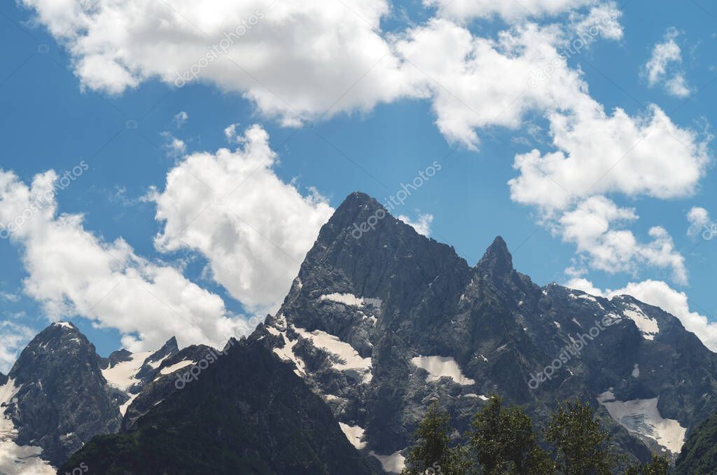 Beautiful mountain landscape with snowy peaks and clouds. highlands in summer.