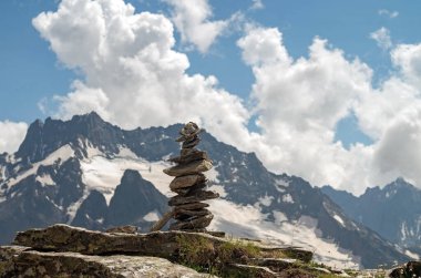 Taşların dengesi. Kayanın tepesinde taşları dengelemek. Kapatın. Mavi gökyüzünde taşların dengesi ve arka planda bir kopya alanı olan dağlar. Taşların dengesi, sürdürülebilirlik kavramı