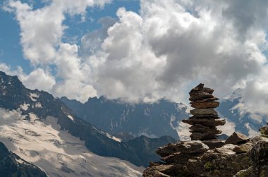 Taşların dengesi. Kayanın tepesinde taşları dengelemek. Kapatın. Mavi gökyüzünde taşların dengesi ve arka planda bir kopya alanı olan dağlar. Taşların dengesi, sürdürülebilirlik kavramı