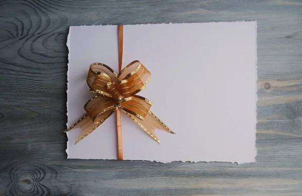 Arco Regalo Con Papel Blanco Sobre Fondo Madera —  Fotos de Stock