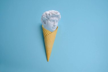 Mavi arka planda heykeli olan dondurma külahı.