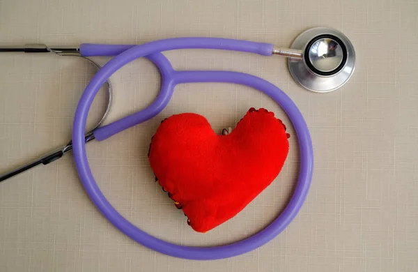 red heart with stethoscope on background