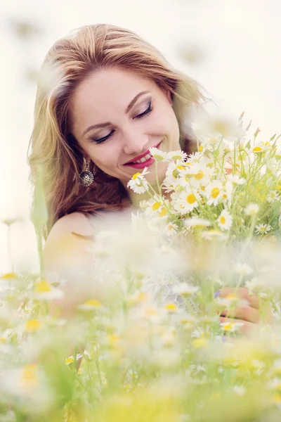 フィールドのヒナギクの花束を持つ若い女性 — ストック写真