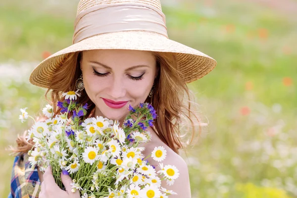 フィールドのヒナギクの花束を持つ若い女性 — ストック写真