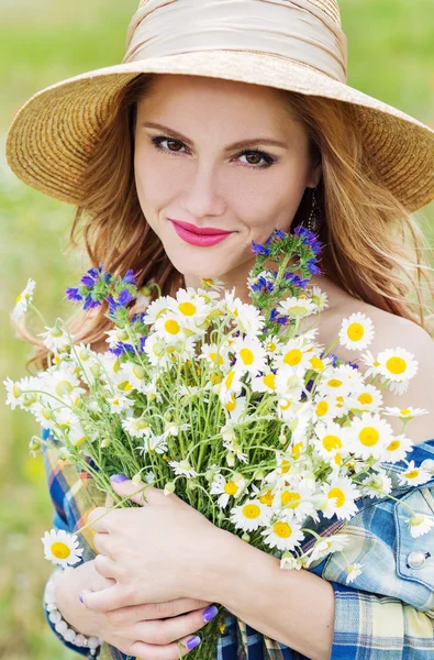 フィールドのヒナギクの花束を持つ若い女性 — ストック写真