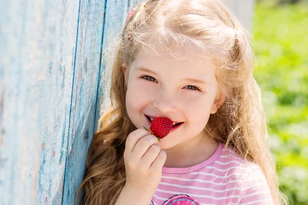 イチゴを食べて幸せな小さな子 — ストック写真