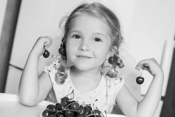 Linda niña comiendo cerezas — Foto de Stock