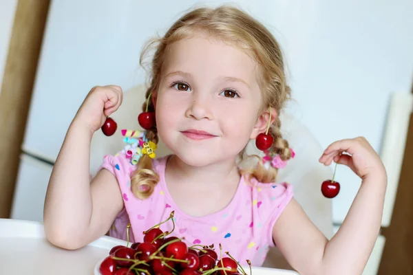 Menina bonito comer cerejas — Fotografia de Stock