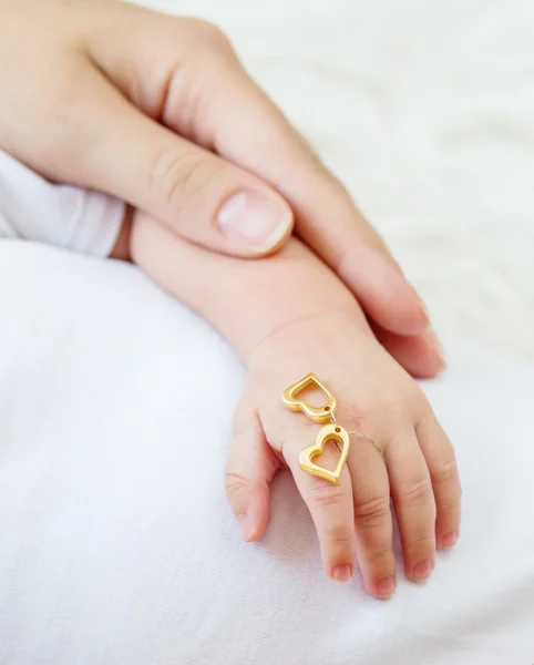 La mano del recién nacido en las manos que cuidan — Foto de Stock