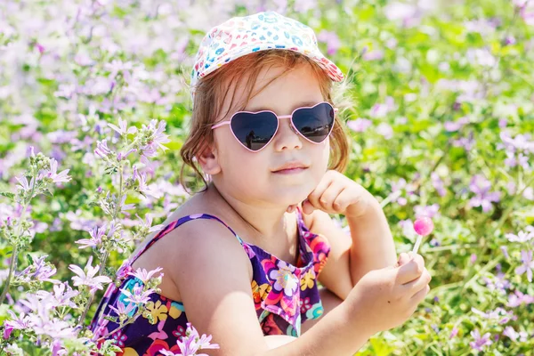 Toddler cute girl with a lollipop outdoors — Stock Photo, Image