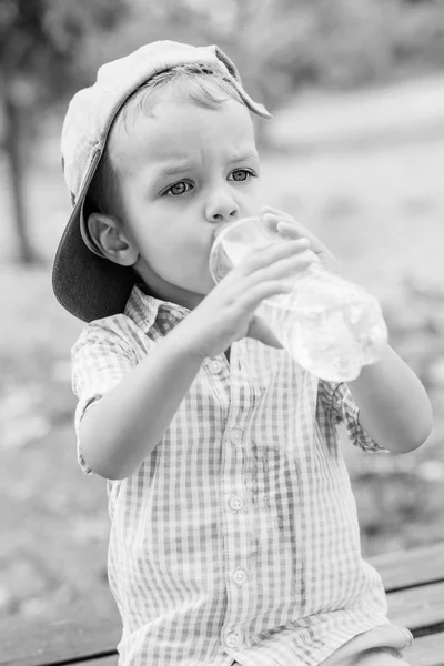 可爱的蹒跚学步的男孩喝水 — 图库照片