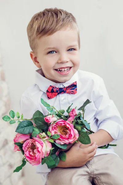 Menino feliz com um buquê de rosas — Fotografia de Stock