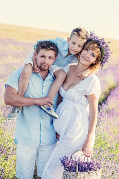 Glückliche junge Familie in einem Lavendelfeld — Stockfoto