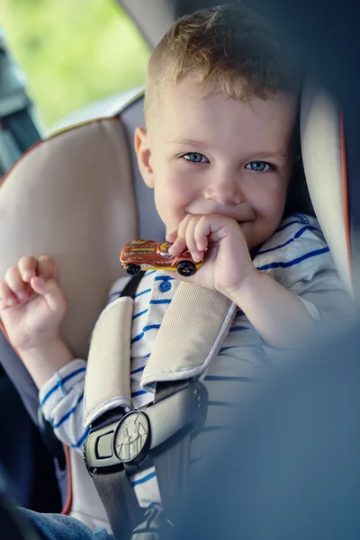 Portrait happy toddler boy sitting in the car — Stock Photo, Image