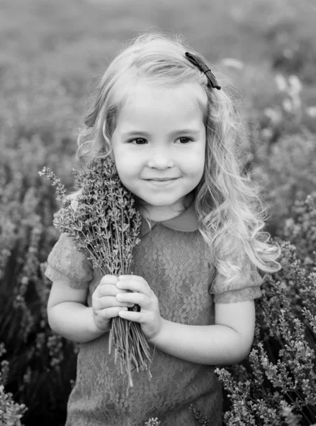 Cute little girl holding a bouquet — Stock Photo, Image