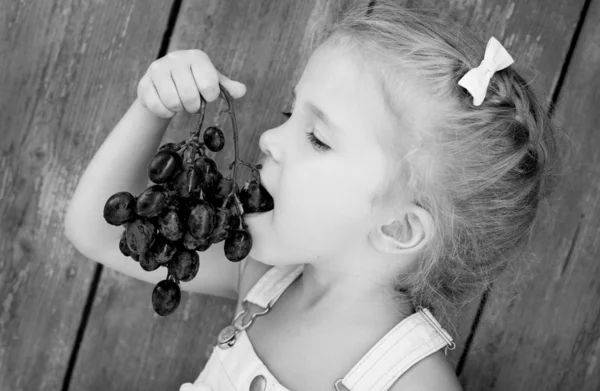 Cute toddler girl eating grapes — Stock Photo, Image