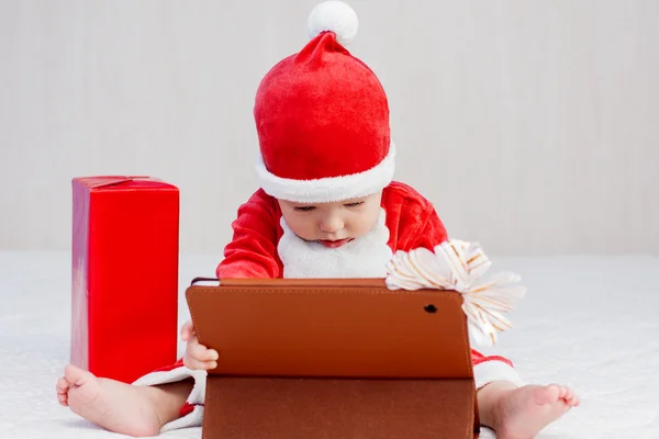 Santa ajudante menino com tablet digital — Fotografia de Stock