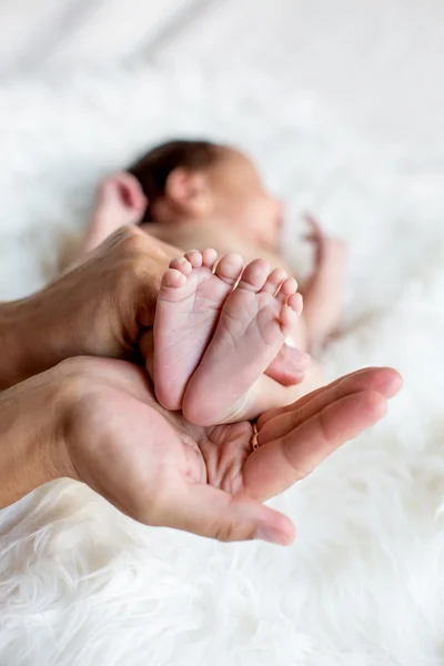 Been van het pasgeboren kind in zorgzame handen — Stockfoto