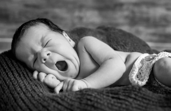 Schattig pasgeboren gaapt liggend op een deken — Stockfoto