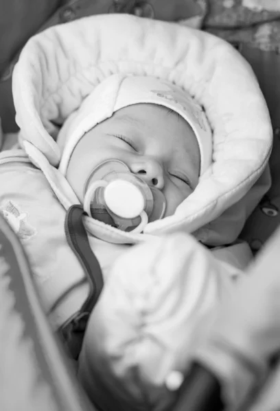 Pasgeboren baby met een fopspeen liggen in een wandelwagen — Stockfoto