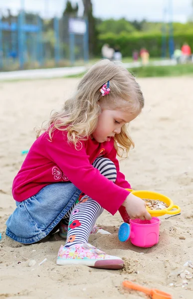 Malá holčička v písku hračky — Stock fotografie