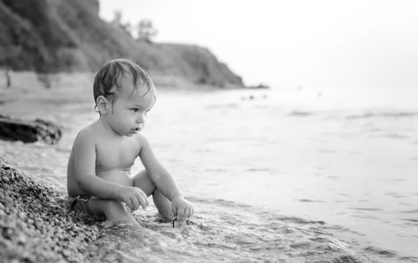 Glada barnet pojke spelar på havet — Stockfoto