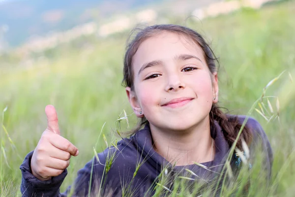 Happy little girl lying on the grass — Stock Photo, Image