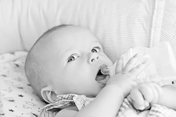 Baby trinkt Wasser vom Liegen im Kinderwagen — Stockfoto