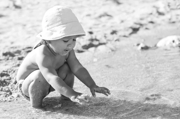 Söt baby spelar på stranden — Stockfoto