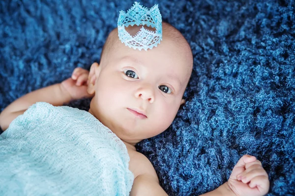 Portrait of a newborn boy with a blue crown — Stock Photo, Image