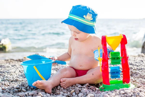 Söta barn pojke spelar på stranden可爱的蹒跚学步的小男孩在沙滩上玩 — Stockfoto