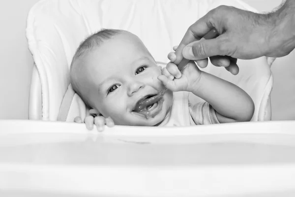 Söt baby boy äter vid ett bord — Stockfoto