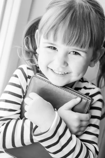 Счастливая маленькая девочка с книгой в руках — стоковое фото