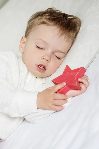 Menino doce dormindo com um brinquedo — Fotografia de Stock