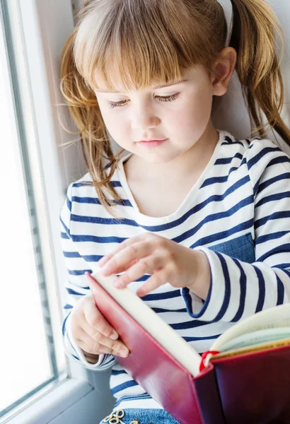 Happy little girl holding a book — Stock Photo, Image