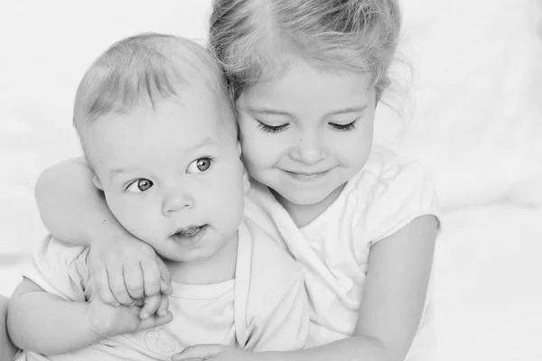 Glückliche kleine Schwester umarmt ihren Bruder — Stockfoto