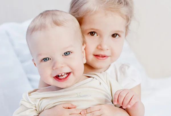 Felice sorellina che abbraccia suo fratello — Foto Stock