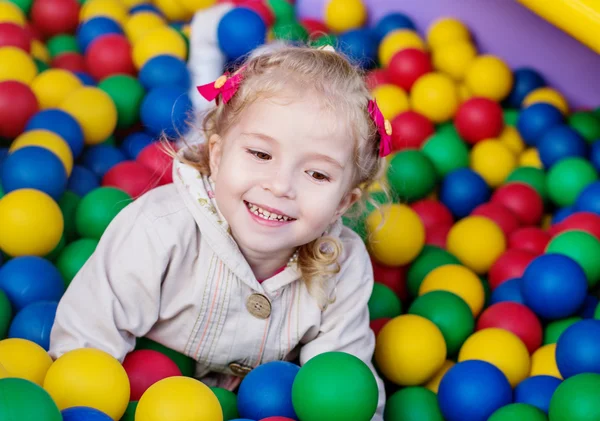 Gelukkig meisje spelen op kleurrijke ballen — Stockfoto