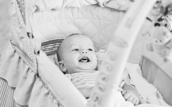Glückliches Baby liegt in der Wiege — Stockfoto