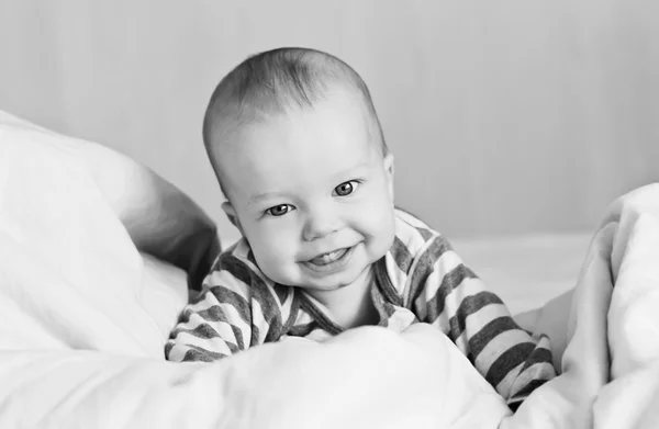 Gelukkig baby in bed op zijn — Stockfoto
