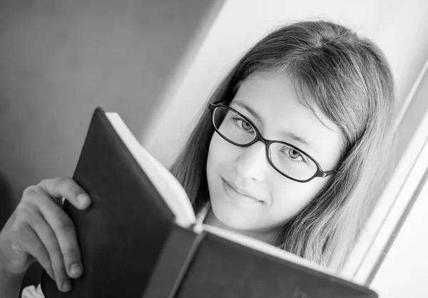 Schattig schoolmeisje in glazen houden een boek — Stockfoto