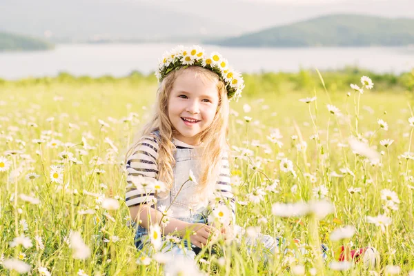 Glückliches kleines Mädchen im Kamillenfeld — Stockfoto