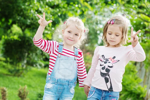 Две счастливые маленькие девочки в парке — стоковое фото