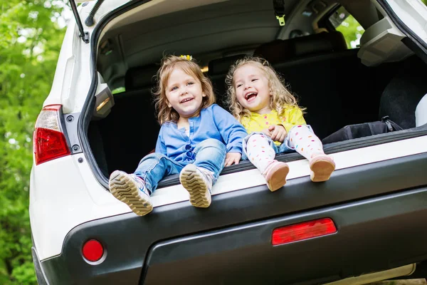 Riant filles tout-petits assis dans la voiture — Photo